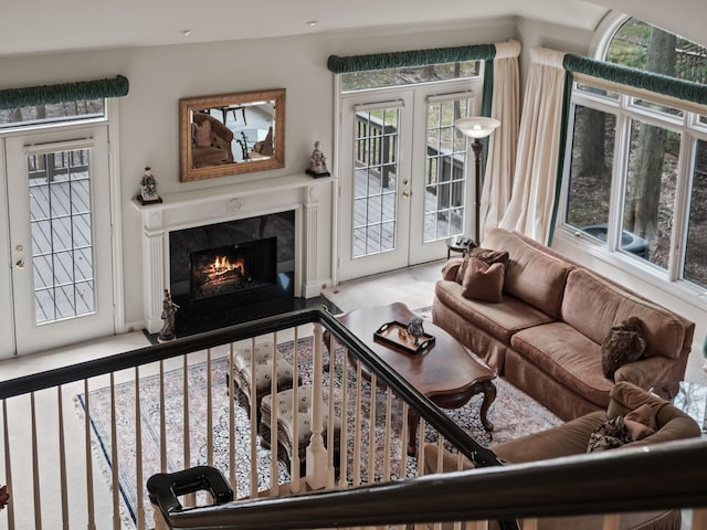 living room with a fireplace, french doors, and a healthy amount of sunlight