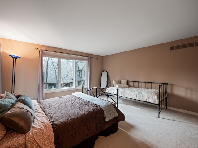 carpeted bedroom with visible vents and baseboards