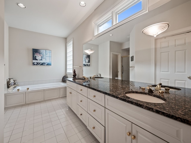 bathroom with a bath, recessed lighting, a sink, tile patterned floors, and double vanity
