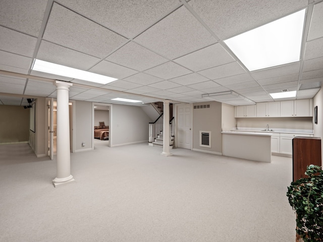 finished below grade area featuring visible vents, stairway, and a drop ceiling