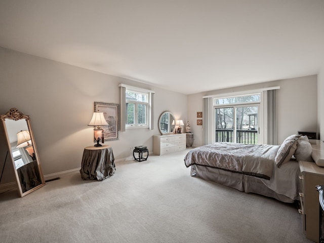 bedroom with baseboards, multiple windows, and carpet
