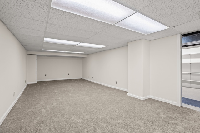 interior space with carpet floors, baseboards, and a drop ceiling