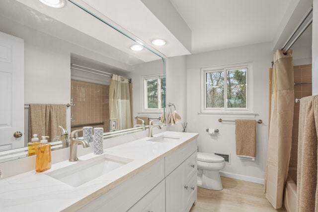 full bathroom featuring toilet, baseboards, a sink, and visible vents