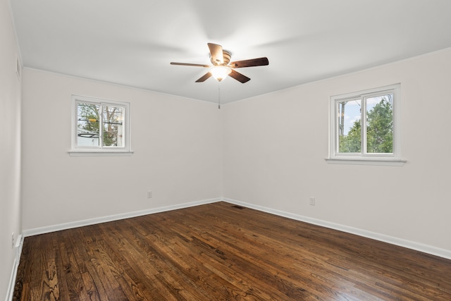 spare room featuring ceiling fan, baseboards, and dark wood-style flooring