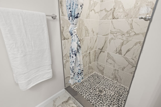 full bath with baseboards, a shower stall, and marble finish floor