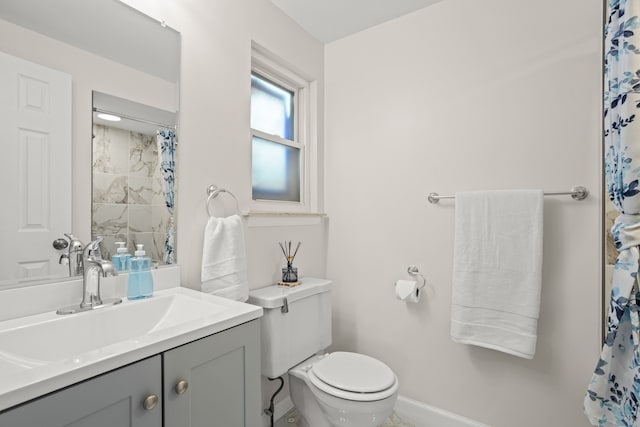 bathroom with curtained shower, vanity, baseboards, and toilet