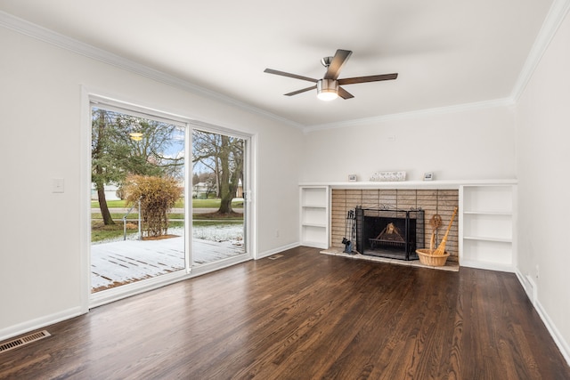 unfurnished living room with visible vents, ceiling fan, a fireplace, crown molding, and dark wood finished floors