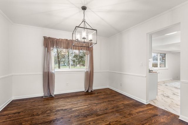 unfurnished dining area featuring baseboards, an inviting chandelier, ornamental molding, and wood finished floors