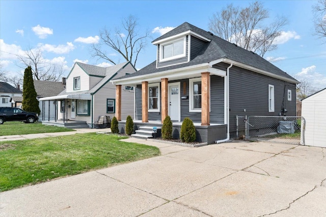11393 Fisher Ave, Warren, MI 48089 - bungalow-style home with a porch, a shingled roof, fence, and a front yard