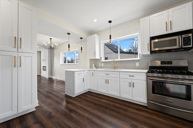 11393 Fisher Ave, Warren, MI 48089 - kitchen featuring white cabinets, tasteful backsplash, appliances with stainless steel finishes, and dark wood-style flooring