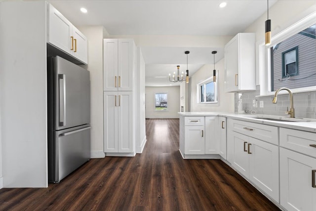 11393 Fisher Ave, Warren, MI 48089 - kitchen with a sink, freestanding refrigerator, a notable chandelier, white cabinetry, and dark wood-type flooring