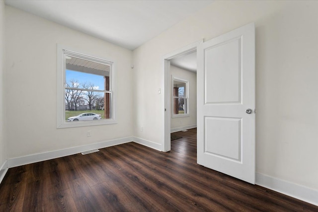 11393 Fisher Ave, Warren, MI 48089 - unfurnished room with visible vents, baseboards, and dark wood-style flooring