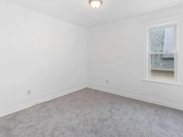 carpeted spare room with baseboards