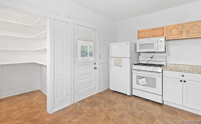 kitchen featuring white appliances, light stone counters, and light brown cabinetry