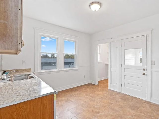 interior space with baseboards, light countertops, and a sink