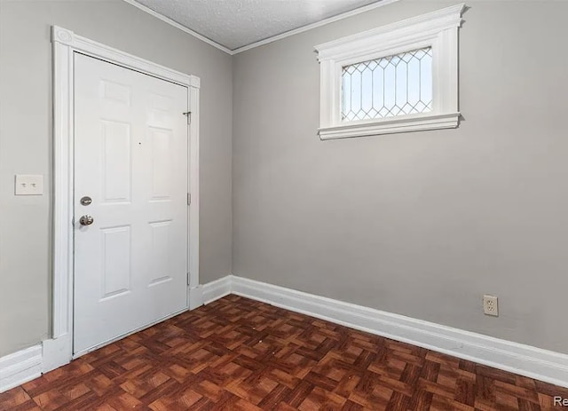 empty room featuring crown molding, baseboards, and a textured ceiling