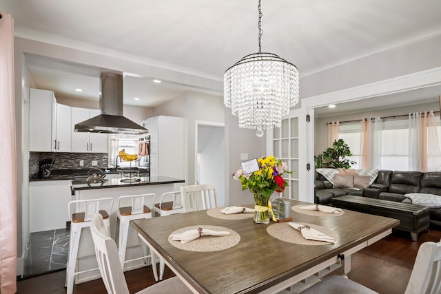dining space featuring a healthy amount of sunlight, dark wood-style flooring, a notable chandelier, and recessed lighting