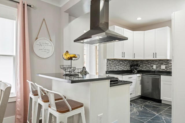 kitchen featuring dark countertops, a kitchen bar, island range hood, stainless steel dishwasher, and marble finish floor