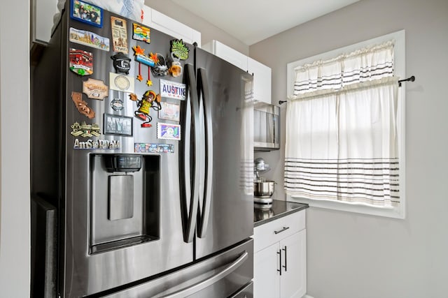 kitchen featuring a healthy amount of sunlight, white cabinets, and stainless steel refrigerator with ice dispenser