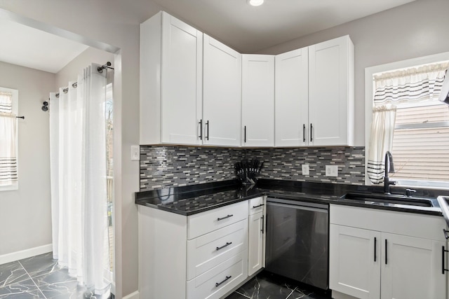 kitchen with baseboards, white cabinetry, stainless steel dishwasher, marble finish floor, and a sink