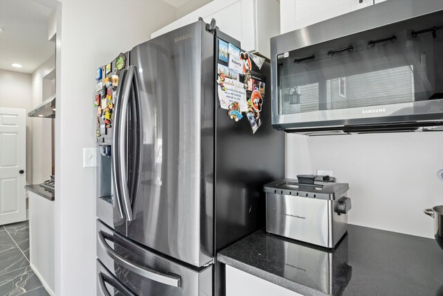 kitchen featuring white cabinets, dark countertops, recessed lighting, stainless steel appliances, and marble finish floor