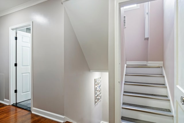 stairway with baseboards, crown molding, and wood finished floors