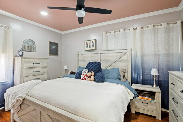 bedroom featuring dark wood-type flooring, ornamental molding, and a ceiling fan