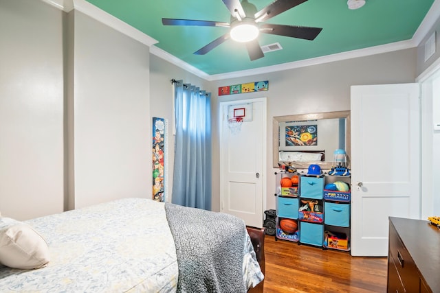 bedroom featuring a closet, crown molding, visible vents, ceiling fan, and wood finished floors