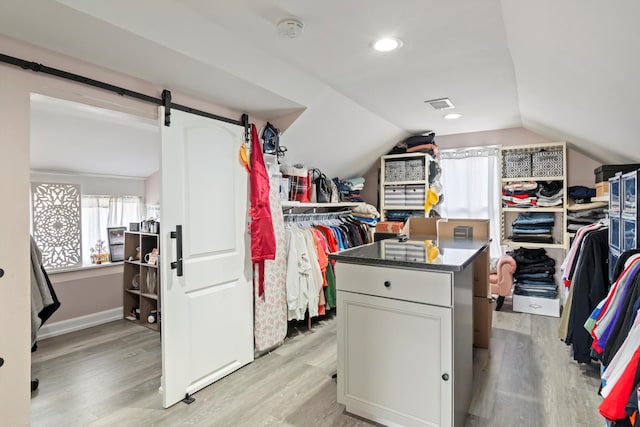 spacious closet featuring light wood-style floors and vaulted ceiling