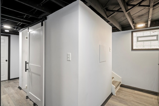 hallway with stairs, light wood-style floors, and baseboards
