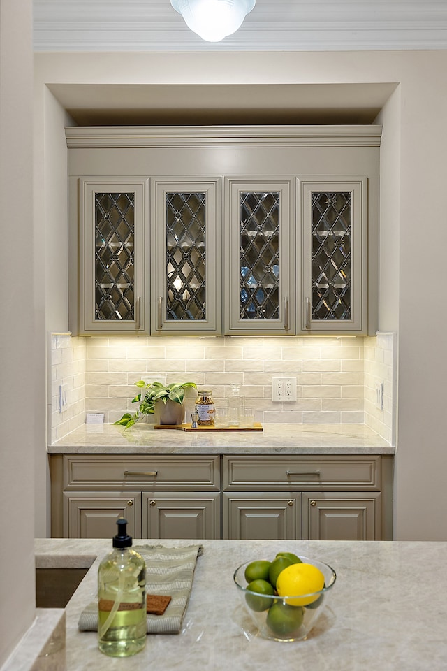 bar with backsplash, a dry bar, and crown molding