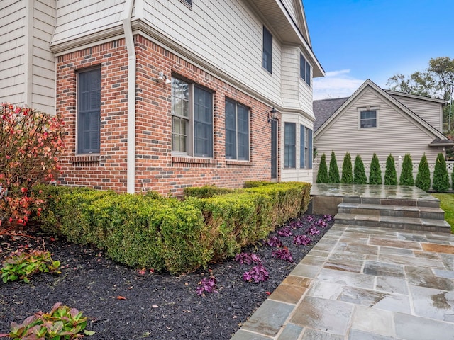 view of side of home with brick siding