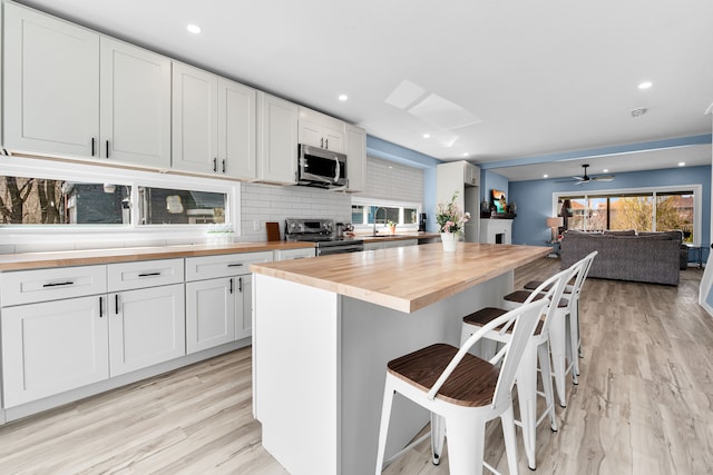 2533 Virginia Park St, Detroit, MI 48206 - kitchen with white cabinets, wood counters, light wood finished floors, and appliances with stainless steel finishes