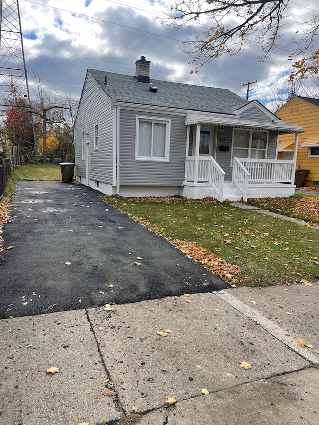 305 S Blvd W, Pontiac, MI 48341 - bungalow featuring covered porch, a chimney, roof with shingles, driveway, and a front lawn