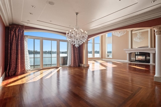82 Chateaux Du Lac, Fenton, MI 48430 - unfurnished dining area featuring a water view, a notable chandelier, a glass covered fireplace, and a wealth of natural light
