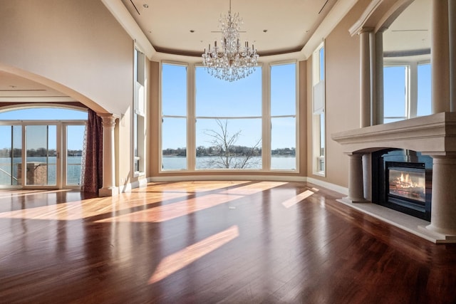 82 Chateaux Du Lac, Fenton, MI 48430 - interior space with decorative columns, wood finished floors, a chandelier, a glass covered fireplace, and a water view