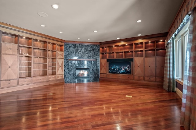 82 Chateaux Du Lac, Fenton, MI 48430 - unfurnished living room with crown molding, wood finished floors, recessed lighting, built in shelves, and a premium fireplace