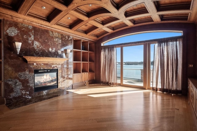 82 Chateaux Du Lac, Fenton, MI 48430 - unfurnished living room featuring ornamental molding, wood finished floors, a high end fireplace, built in shelves, and coffered ceiling