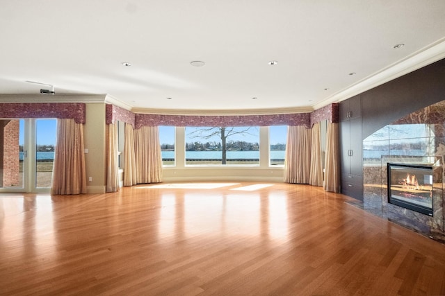 82 Chateaux Du Lac, Fenton, MI 48430 - unfurnished living room with crown molding, a water view, a fireplace, and wood finished floors