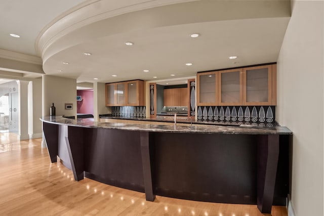 82 Chateaux Du Lac, Fenton, MI 48430 - interior space with dark stone counters, recessed lighting, glass insert cabinets, and light wood finished floors