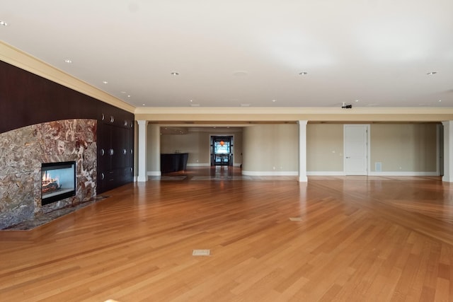 82 Chateaux Du Lac, Fenton, MI 48430 - unfurnished living room featuring baseboards, ornamental molding, wood finished floors, and a fireplace