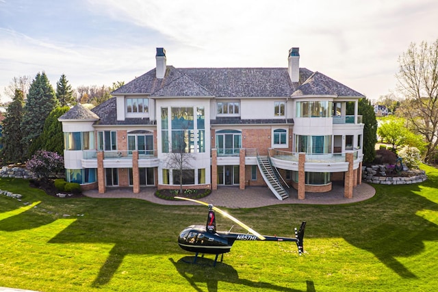 82 Chateaux Du Lac, Fenton, MI 48430 - rear view of house with a sunroom, a patio area, and brick siding