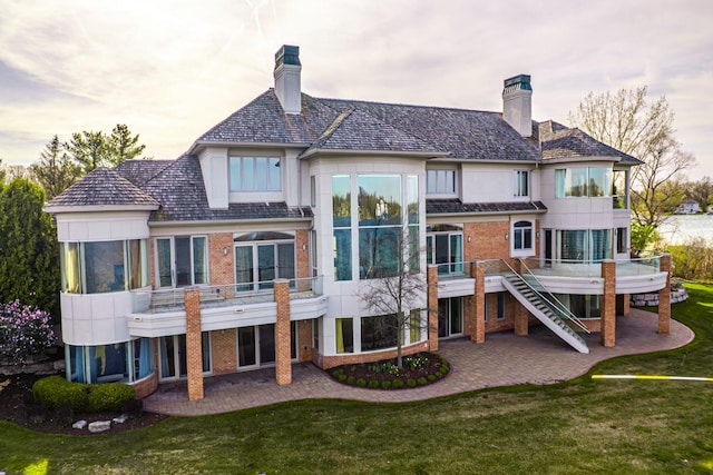 82 Chateaux Du Lac, Fenton, MI 48430 - back of house featuring a patio, a chimney, and brick siding