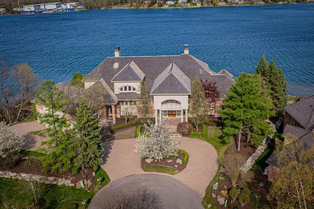 82 Chateaux Du Lac, Fenton, MI 48430 - view of front of home with a water view, curved driveway, a chimney, and stone siding