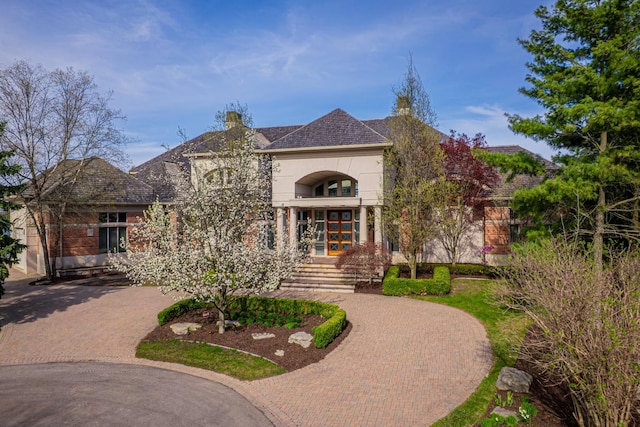 82 Chateaux Du Lac, Fenton, MI 48430 - french country style house featuring curved driveway, french doors, a balcony, and stucco siding