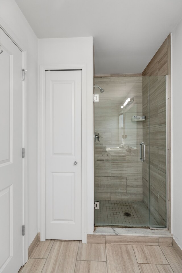bathroom with baseboards and a stall shower