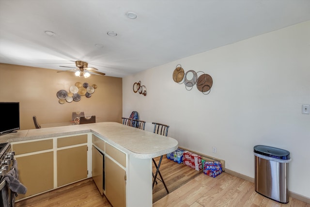 29190 Heritage, Southfield, MI 48076 - kitchen with light countertops, light wood-type flooring, a ceiling fan, and a breakfast bar area