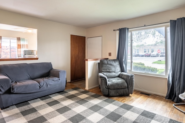 living room with healthy amount of natural light, wood finished floors, and baseboards