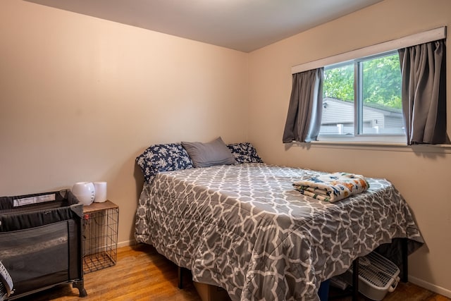 bedroom featuring baseboards and wood finished floors