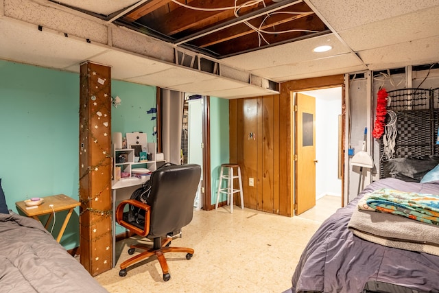 bedroom with tile patterned floors, a paneled ceiling, and an office area